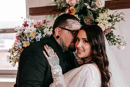 Tattooed wedding couple hugging