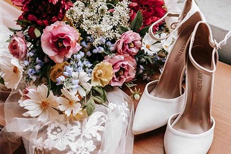 wedding bouquet against white pair of high heels